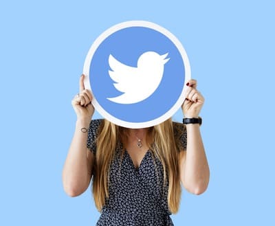 A woman holds up the logo of Twitter, one of her social media outlets.